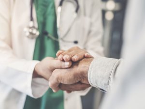 Health worker holding patient's hand