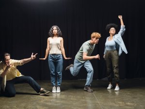 full length of young multiethnic actors rehearsing in different poses on stage of theater,stock image
