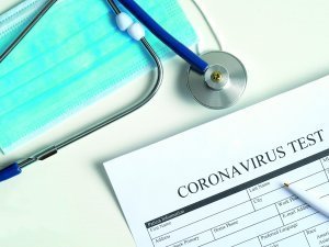 Coronavirus blood test concept. Laboratory table with medical form Coronavirus test, respiratory mask, stethoscope, pills. 2019-nCoV Coronavirus originating in Wuhan, China